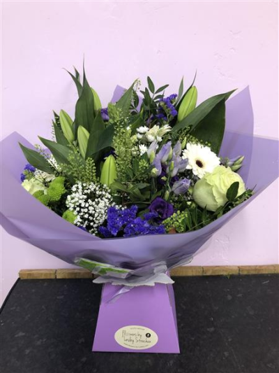 Symphony - An elegant bouquet of white and purple blooms including scented oriental lilies, statice, limonium and wispy foliage.
Aqua Packed, this Bouquet is delivered in water.
Picture shows standard size option